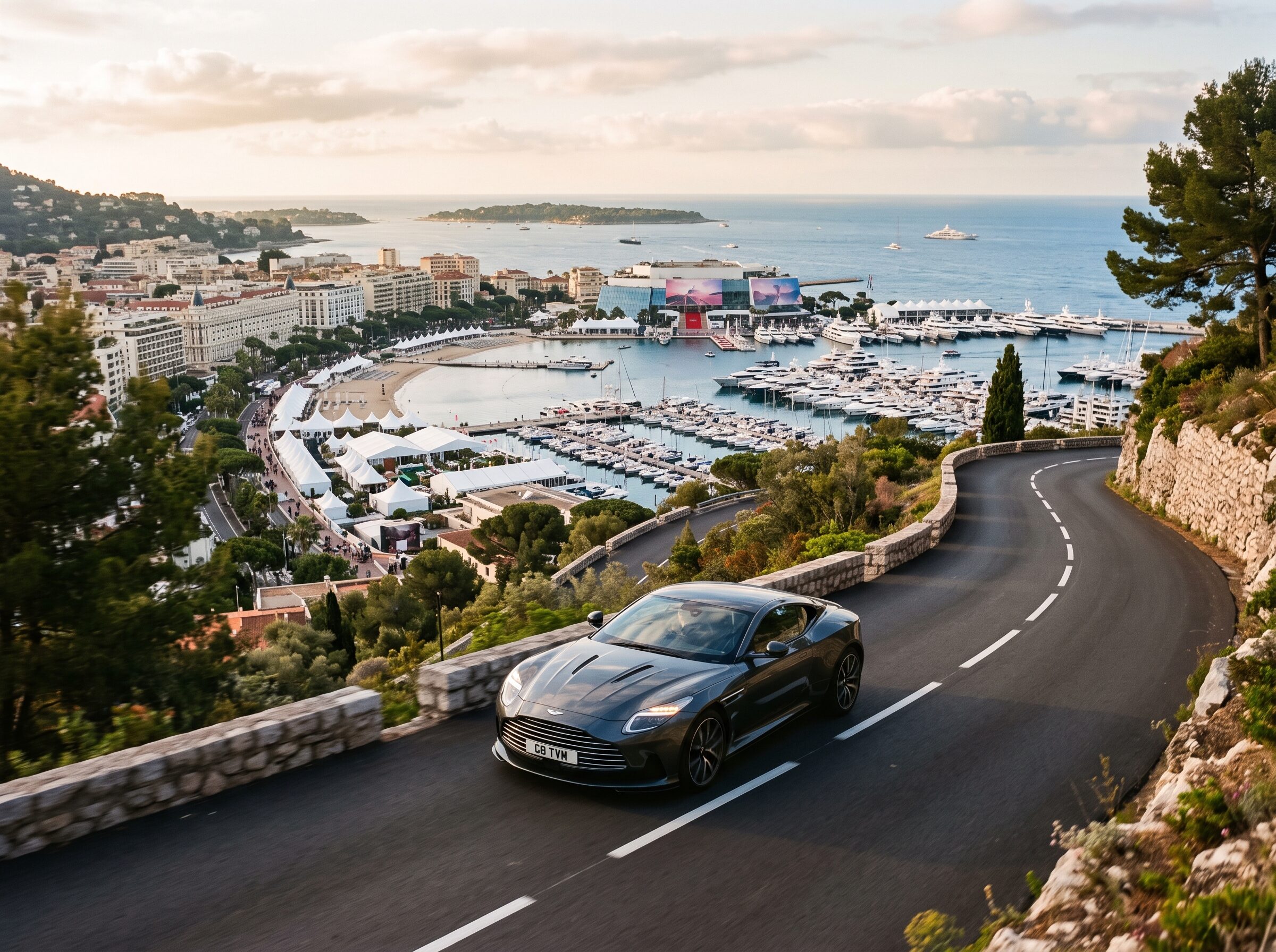 A grand tourer descending toward Cannes and the festival waterfront