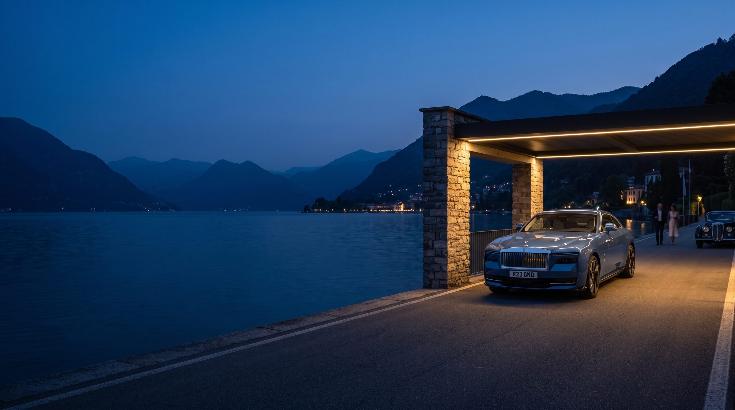 A grand tourer waiting beside Lake Como beneath warm architectural light at blue hour